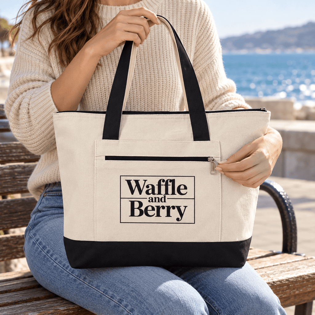 Illustrative close-up of a model holding the Natural/Black Waffle and Berry canvas tote, showing its zippered front pocket.