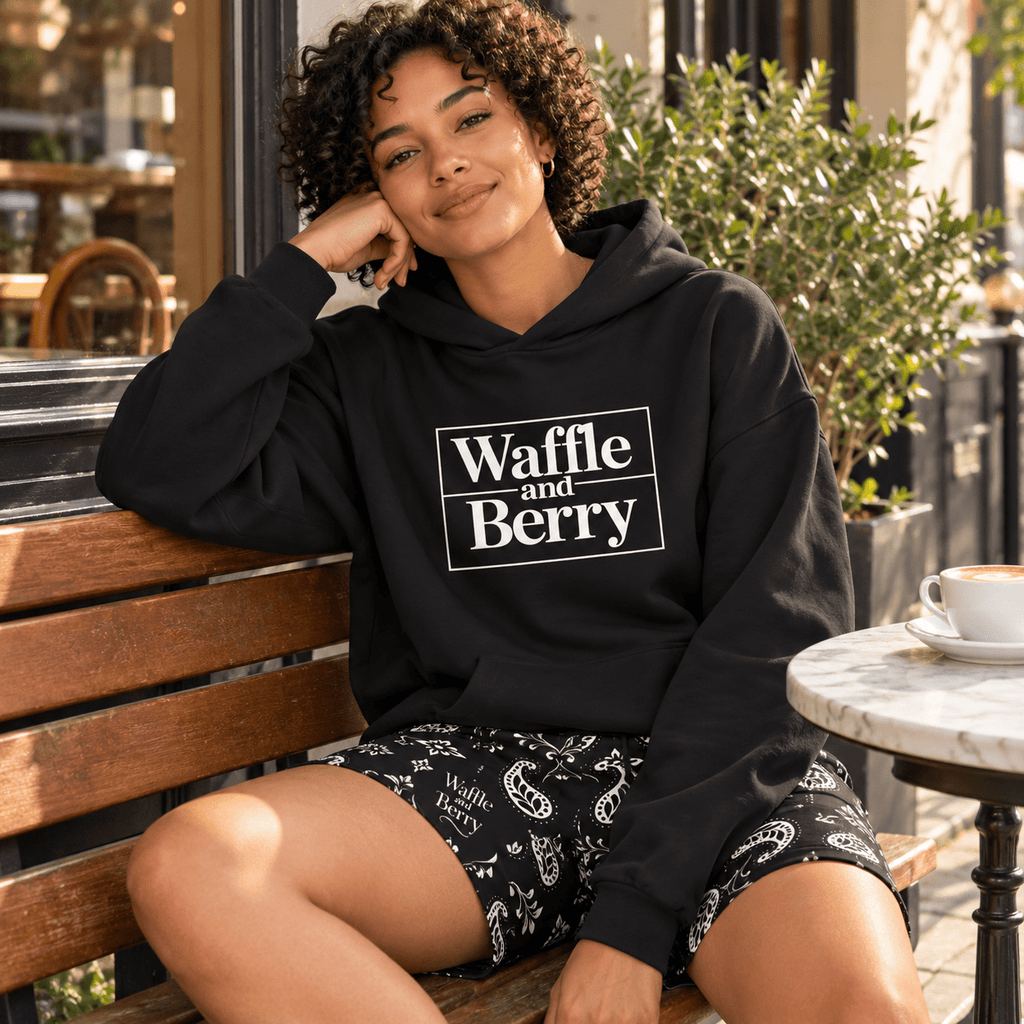 Model wearing Waffle and Berry Hoodie and paisley shorts, seated
