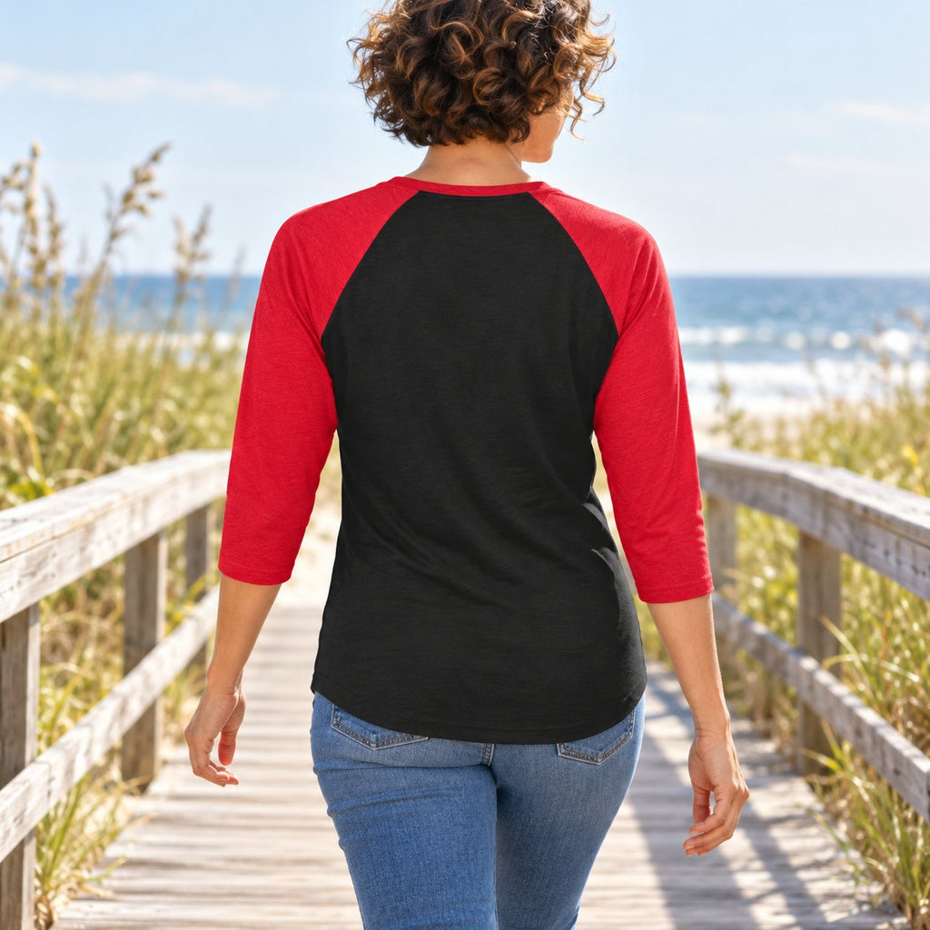 Illustrative model wearing the Black/Red New York Wins raglan shirt on a coastal boardwalk, plain back view.