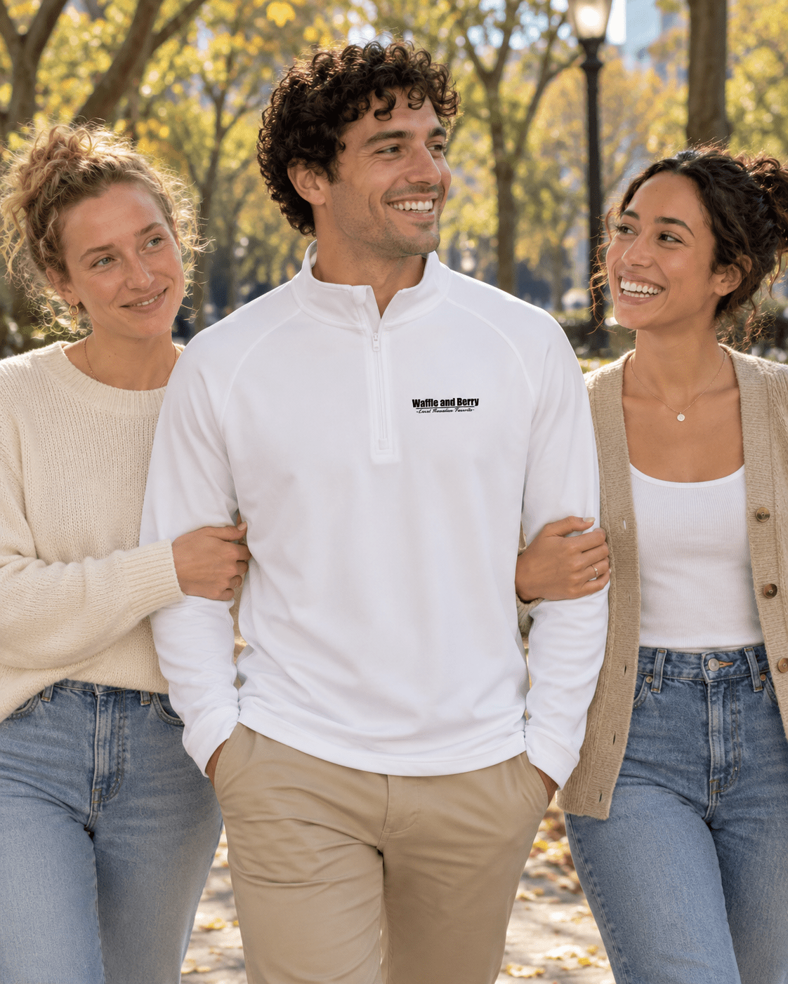 AI styling illustration: men's Sport-Tek ST850 quarter-zip in white, modeled beside the two sisters, park setting.