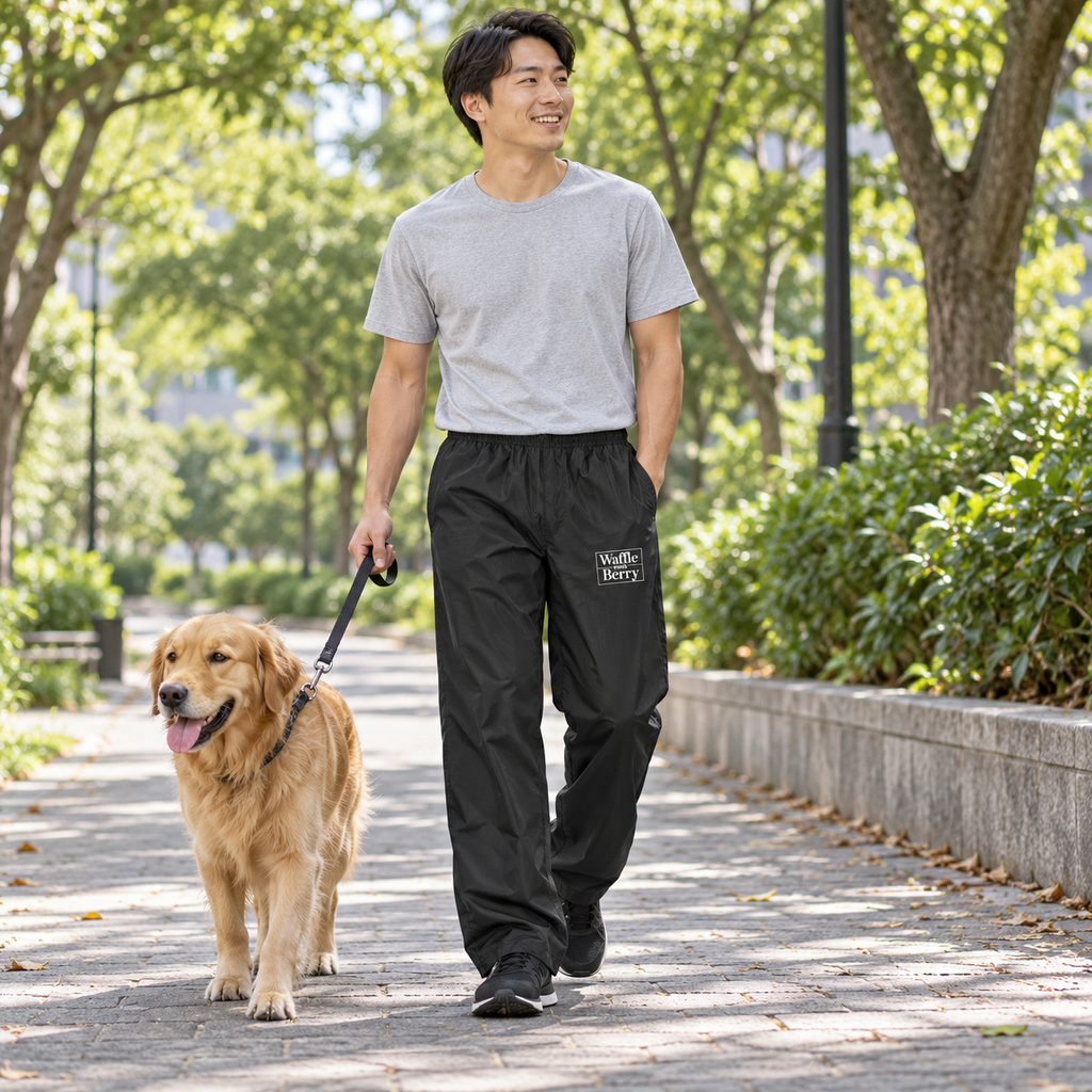 AI-generated lifestyle visualization: adult model walking a dog in black Waffle and Berry wind pants, white logo on wearer-left front thigh. Fit and print placement illustrative; not a physical sample photograph.